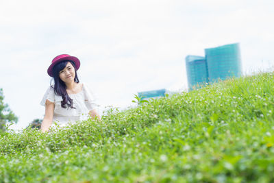 Full length of young woman in grass against plants