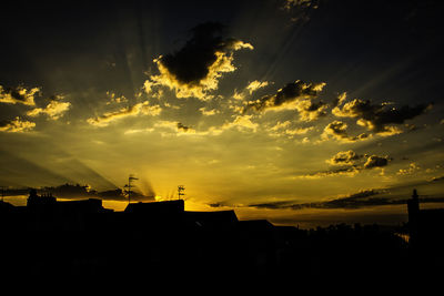 Silhouette city against sky during sunset