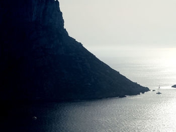 Scenic view of sea and mountains against sky