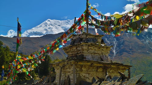 Multi colored flags on mountain against sky