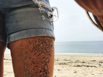 Midsection of woman standing at beach