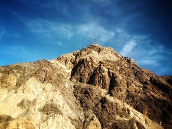 Low angle view of mountain against blue sky