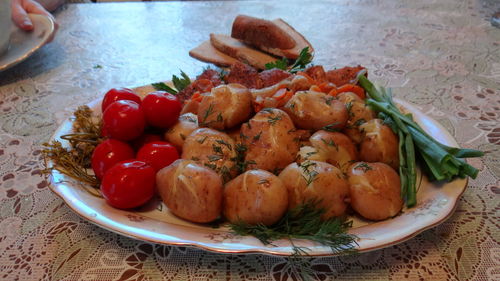 Close-up of boiled potatoes and tomatoes in plate served on table