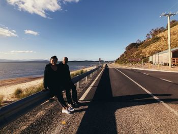 Men standing on road against sky