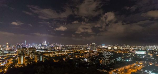 Illuminated cityscape against sky at night