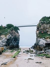 Rock formation on bridge against sky