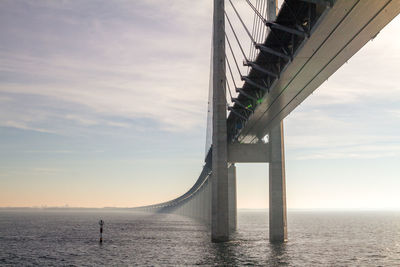 Bridge over sea against sky during sunrise 