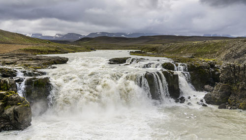 Scenic view of waterfall against sky