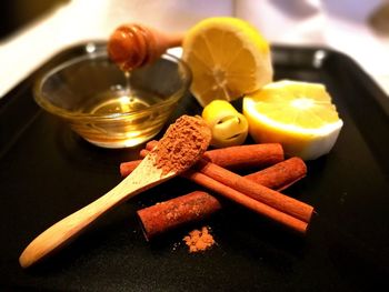 Close-up of cinnamon with lemon on serving tray on table
