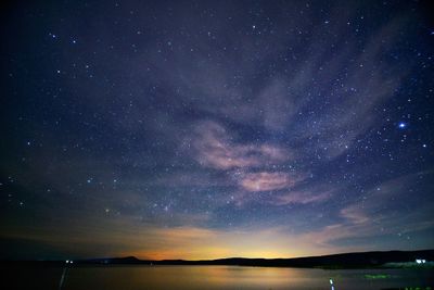 Scenic view of lake against star field at night