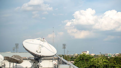 Communications tower in city against sky