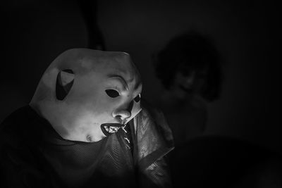 Close-up of person in costume and mask at darkroom