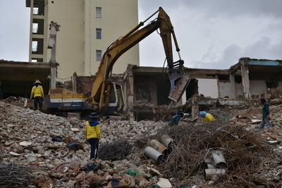 Low angle view of construction vehicle at damaged building