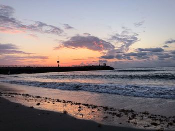 Scenic view of beach against sky during sunset