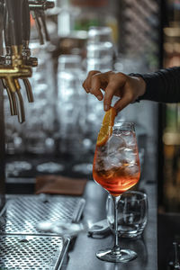 Close-up of hand holding wine glass on table