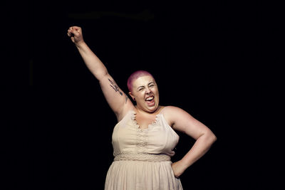 Woman posing against black background