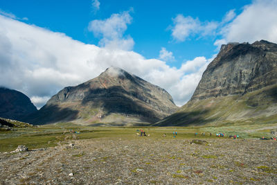 People on land against mountains