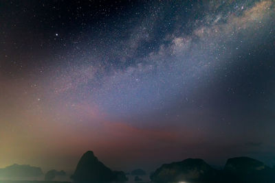 Low angle view of silhouette mountain against sky at night