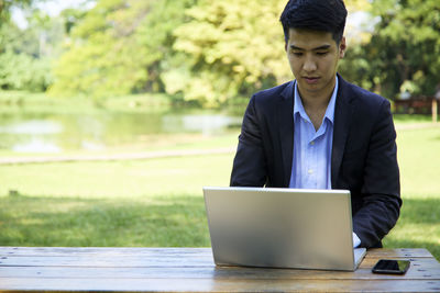 Young man using mobile phone on table