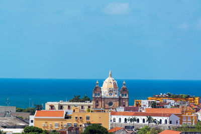 San pedro claver in city by sea against blue sky