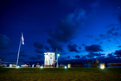 Illuminated building against blue sky at night