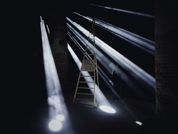Sunbeam falling on man standing by ladder in room