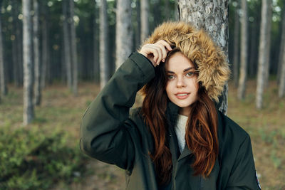 Portrait of young woman standing in forest