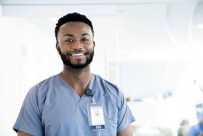 Portrait of confident doctor in hospital corridor