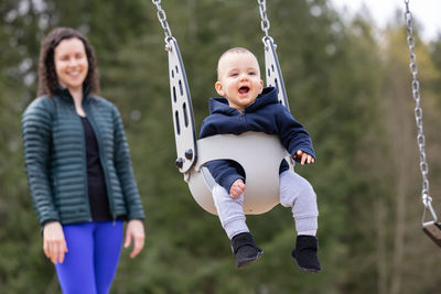 Low angle view of boy sitting on swing