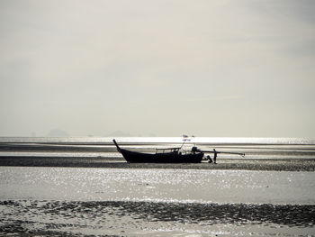 Boat moored on sea against sky