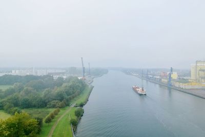 High angle view of river amidst cityscape against sky