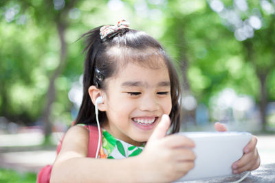 Close-up of smiling girl holding smart phone