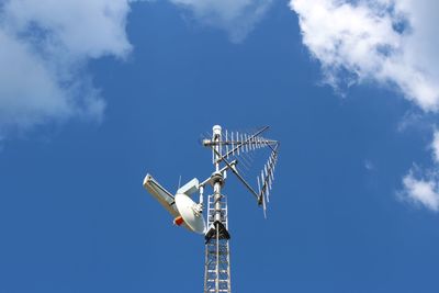 Low angle view of communications tower against blue sky