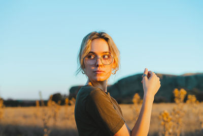 Portrait of young woman wearing sunglasses against sky