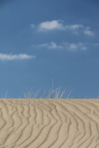 Scenic view of sand dunes against sky