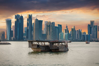 Skyscrapers in city at sunset