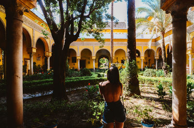 Rear view of woman walking outside historic building