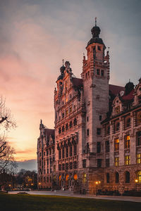 Low angle view of illuminated building against sky at sunset