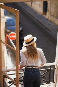 Rear view of woman standing by railing