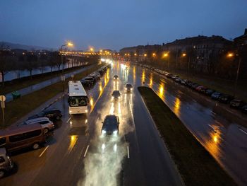 Cars on illuminated road against sky in city at night