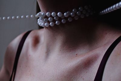 Midsection of woman wearing pearl necklace