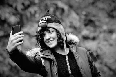 Smiling woman taking selfie while standing outdoors