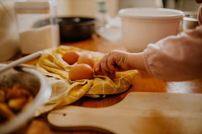 Cropped hand of person preparing food on table