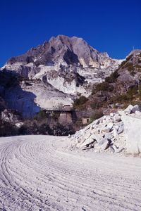 Scenic view of marble quarries and mountains against clear blue sky