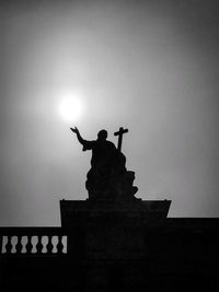 Low angle view of silhouette statue against sky