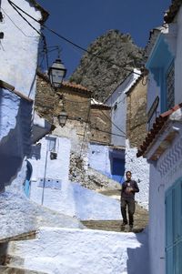 People walking by houses against buildings