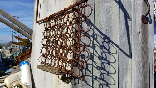 Low angle view of chain hanging on metal wall