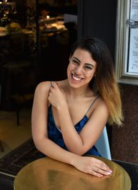 Portrait of young woman sitting on table