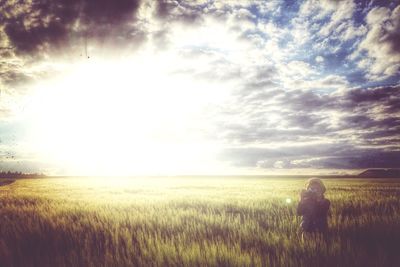 Scenic view of field against cloudy sky