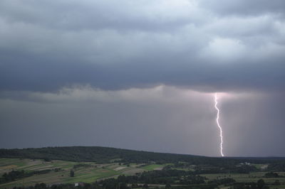 Scenic view of lightning over land against sky